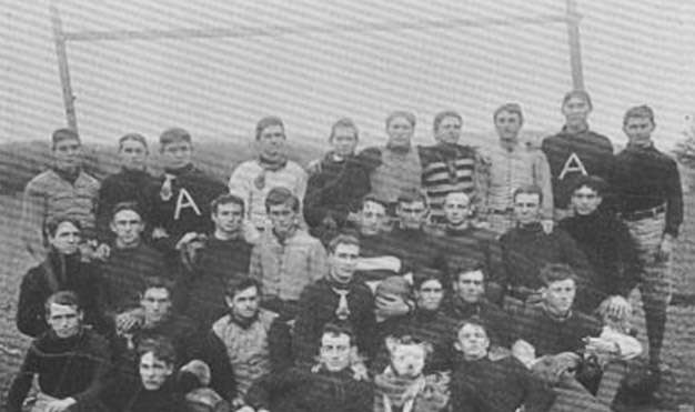 Group of young white men gathered on football field