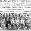 Group of young white women in matching athletic jackets with their male and female coaches kneeling in front of Arkansas Tech University billboard