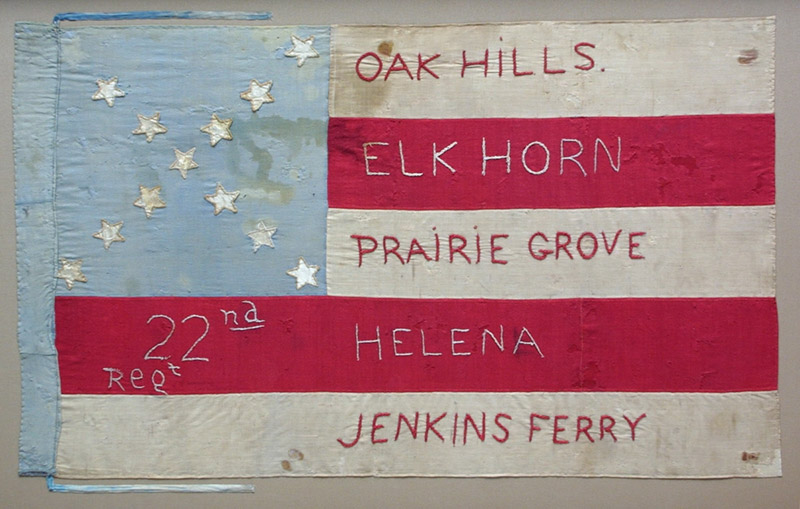 Flag with stars on blue field in upper left corner and text on red and white stripes