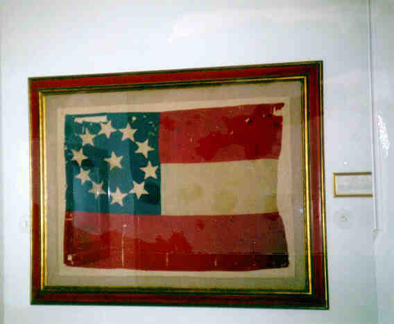 Framed red white and blue flag with star in center of circle of stars on blue field