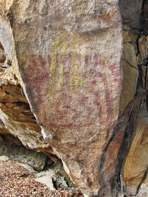 Faded red painting on rock wall