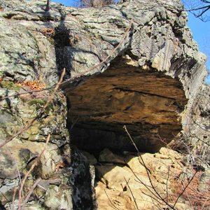 Exterior of cave entrance with rock outcroppings on mountain side