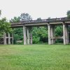 Concrete railroad bridge with supporting structure across field