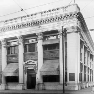 Two-story building with four columns and window awnings