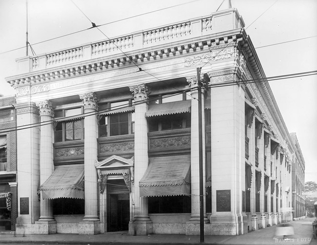 Two-story building with four columns and window awnings
