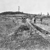 Two white men in large field with railroad tracks