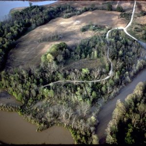 Aerial view park winding road through fields forest near wetlands surrounded large bodies of water