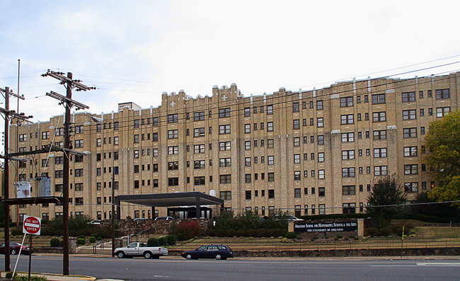 Lengthy multistory building with street and parked cars