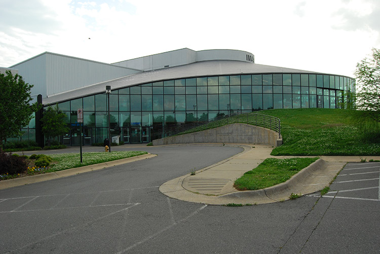 Round building with glass wall and parking lot