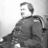White man with mustache in military uniform sitting in chair