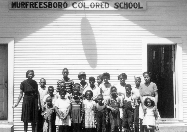 Class of African-American students and teachers with school building "Murfreesboro Colored School"