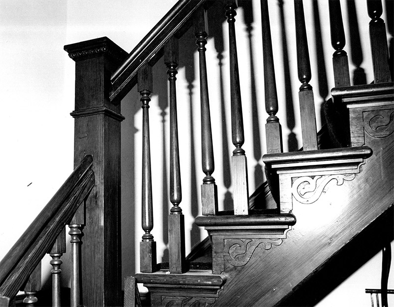 Close-up of wooden staircase with hand railing