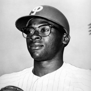 African-American man wearing glasses and cap in Philadelphia Phillies uniform with glove
