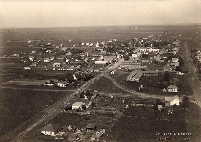 Town buildings and streets as seen from above with photo watermark saying "Downing's Studio Stuttgart, Arkansas"