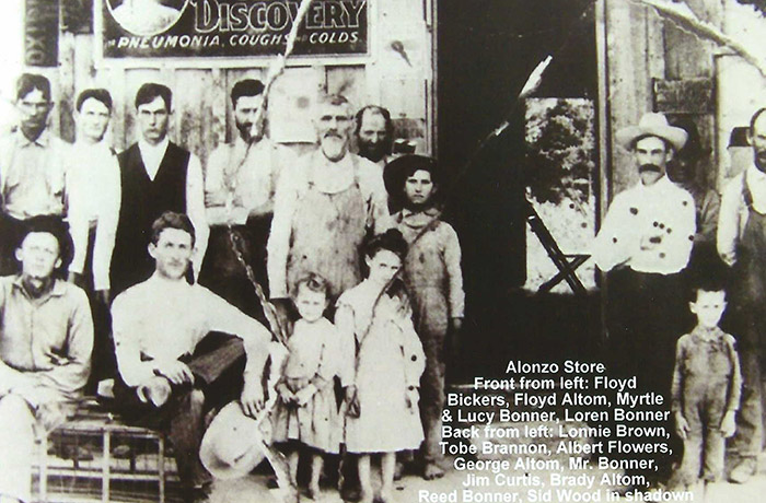 Group of white men and children outside store building