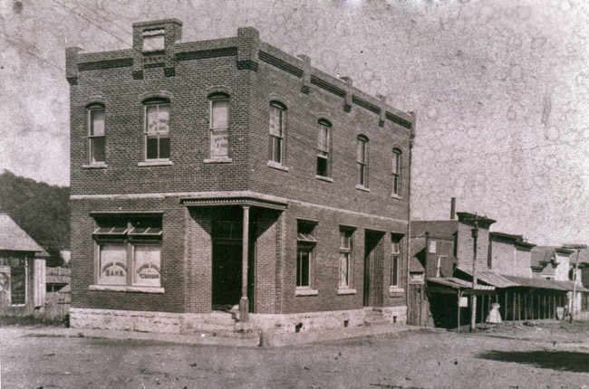 two story brick building on corner of street with other businesses