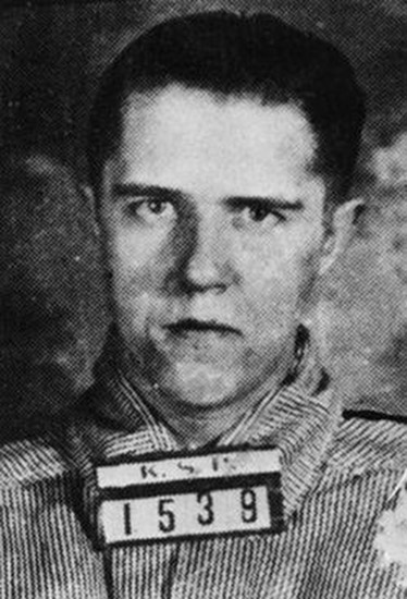 White man in striped shirt with "K.S.P. 1539" sign