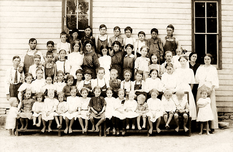 Group of young white children outside school building