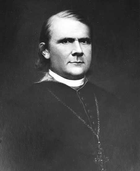 White man in bishop's robes wearing a cross necklace