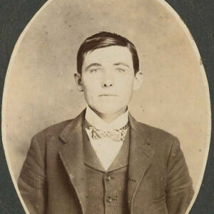 Young white man in suit jacket vest and bow tie in photo with oval mat