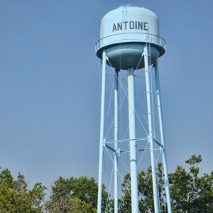 Blue "Antoine" water tower with trees growing at its base