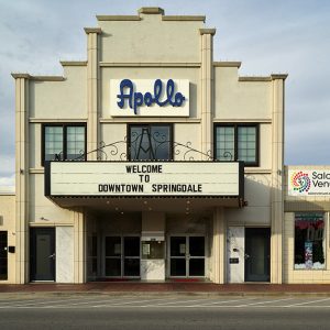 Multistory "Apollo" theater building with "Welcome to Downtown Springdale" on its marquee