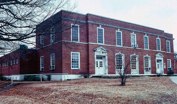 Two-story brick building with framed windows and doorways