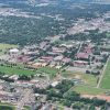 College campus buildings and grounds with town and countryside as seen from above