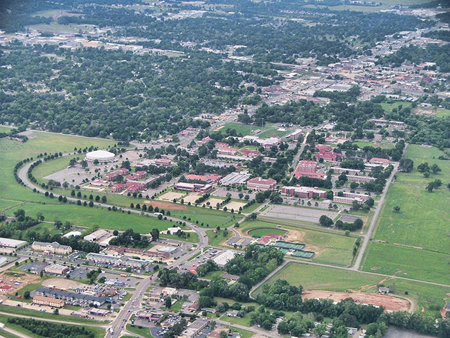 College campus buildings and grounds with town and countryside as seen from above