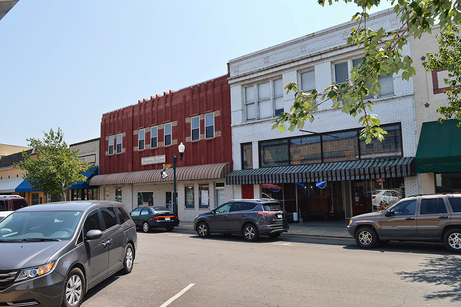 Multistory storefronts with parked cars on street