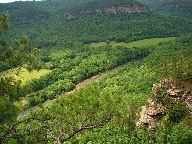 Aerial view of tree covered river valley with rock outcroppings