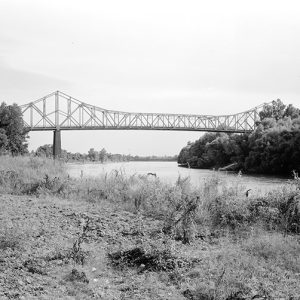 Side view of steel truss bridge over river