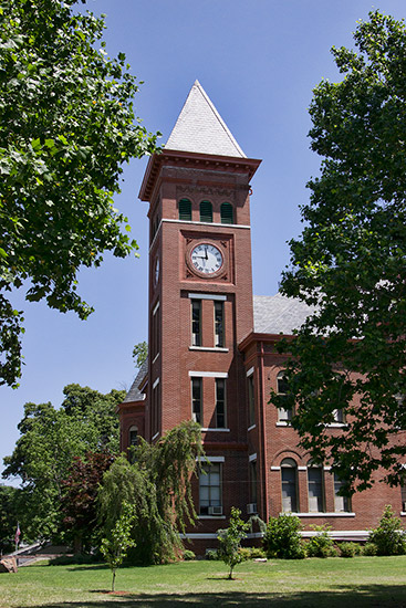 red brick building with clock tower and trees