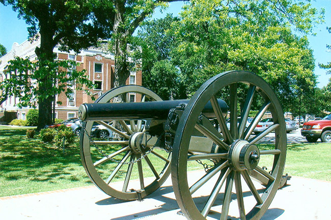 Cannon on wheels with brick court house and grounds