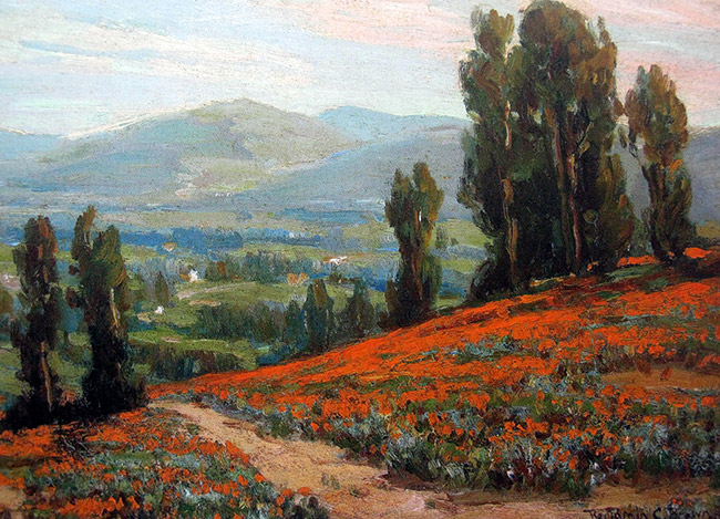 Rolling hills covered in trees and orange flowers with mountains
