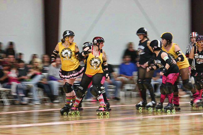 Young white women in yellow shirts racing on roller skates