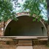 stone and concrete hemispherical stage outside with trees
