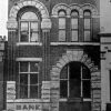 Elaborate tall building with arched entrance saying "bank" and arched windows