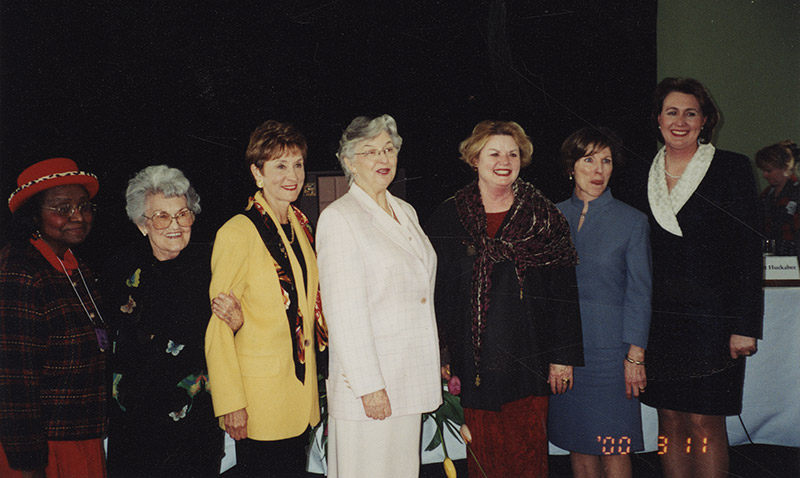 Older African-American woman standing with group of older white women