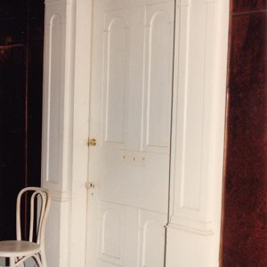 Interior door with decorative frame and chair