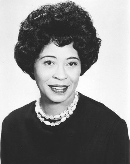African-American woman wearing dark colored dress with double strain shell necklace