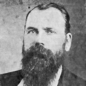 White man with long beard in suit