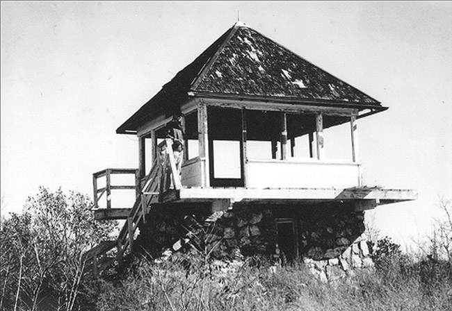 Lookout tower with stone foundation and pyramid shaped roof with stairs