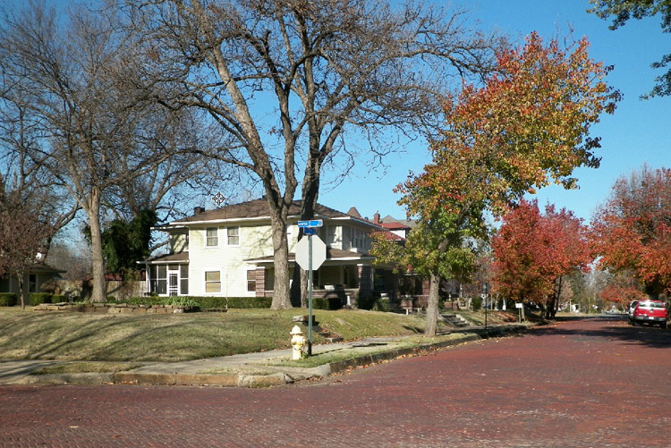 red brick street with two-story houses and fall foliage