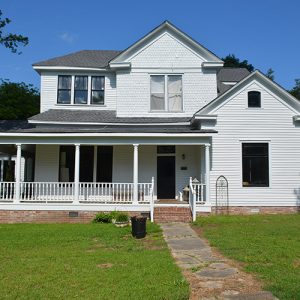 Two-story house with covered porch and brick foundation