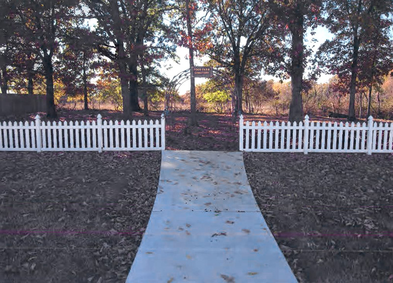 Cemetery gate and white picket fence with walking path