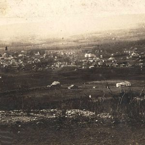 View from hill of small town with houses and water tower in the background