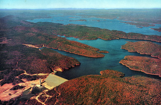 View of concrete dam and lake with islands from above