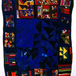 deeply blue quilt with irregular border of multicolored stripes and triangles