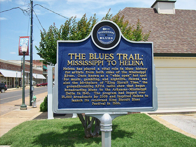 "The Blues Trail: Mississippi to Helena" sign by building on street corner